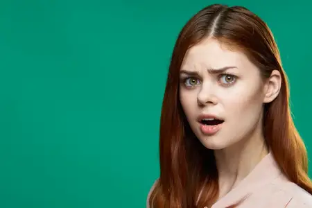Крупный план симпатичной женщины с привлекательным взглядом на зеленом фоне в студии