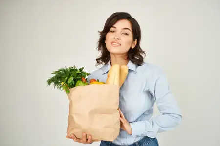 Женщина с пакетом овощей и продуктов из супермаркета, крупный план