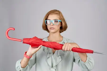 Женщина в очках с красным зонтом в руке и часами, модель, обрезанный вид