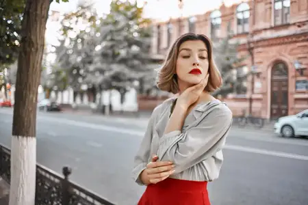 Женщина на улице возле здания, прогуливается, красные губы