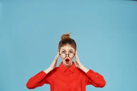 Женщина в элегантном красном деловом пиджаке на официальном синем фоне