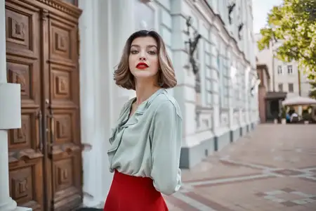 Жизнерадостная женщина на улице, прогуливается возле здания