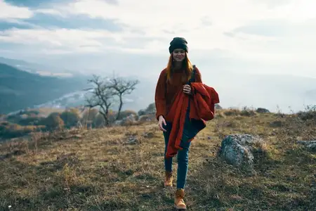 Жизнерадостная женщина-туристка с собакой на природе