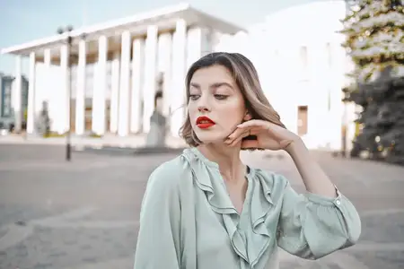 Симпатичная женщина на свежем воздухе в городе, рядом со зданиями, наслаждается образом жизни