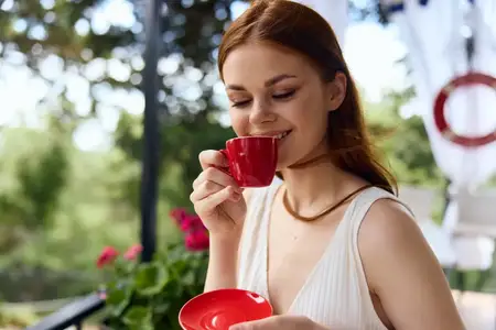 Красивая женщина пьет кофе на открытом воздухе