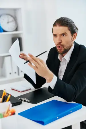 Менеджер работает в офисе с синей папкой для документов