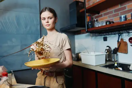 Женщина стоит на кухне, держа миску с едой над кастрюлей в центре комнаты