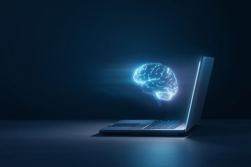 Futuristic holographic digital brain emerging from a laptop, symbolizing artificial intelligence, neural networks and data processing in a dark technological environment.