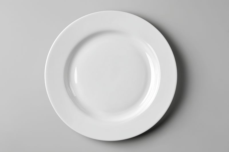 Plate empty white top view on gray background, minimal ceramic dish for food styling and product photography, clean tableware composition with shadow lighting